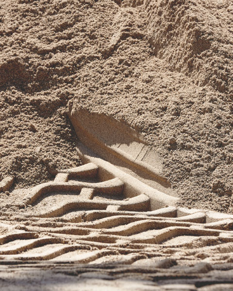 Abdruck einer Baumaschine im Sand auf einer Baustelle
