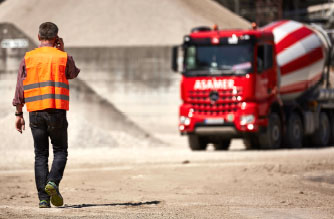 Bauarbeiter auf einer Baustelle beim Betonieren mit Betonmisch-LKW